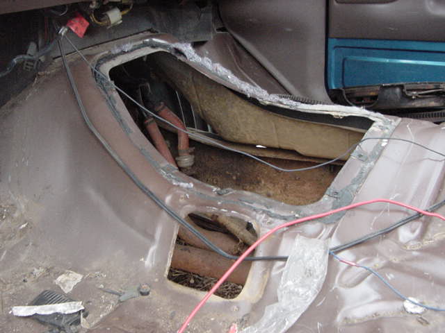 Interior floor pan with exposed transmission tunnel and wiring