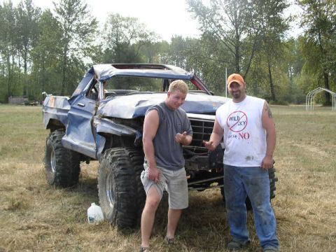 1979 Ford Bronco - A heavily modified 1979 Ford Bronco, likely used for off-roading, is shown with two men standing beside it.