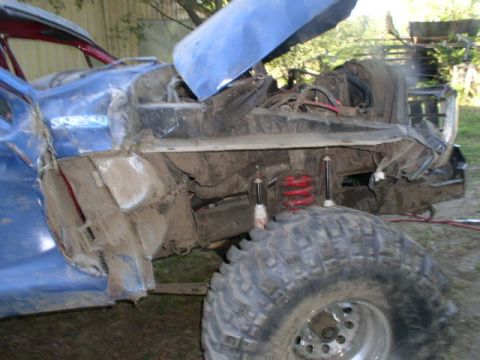 1979 Ford Bronco - This heavily modified vehicle shows significant front-end damage, with the hood propped open and suspension components visible.