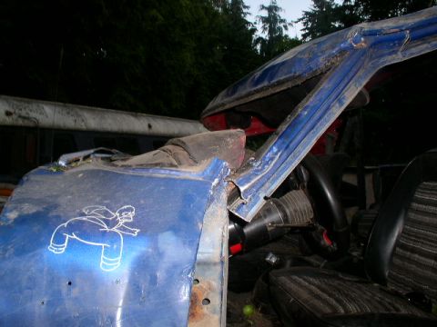 1979 Ford Bronco - The interior of a damaged blue vehicle is visible, with a cartoon sticker on the door and another vehicle in the background.