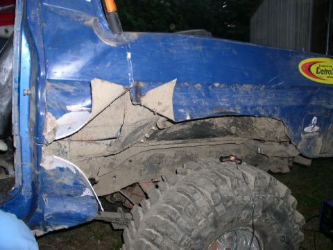 1979 Ford Bronco - This blue vehicle displays significant body damage and a large tire, with visible text on the lower right.