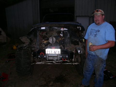 1979 Ford Bronco - Man with a beer stands beside a severely damaged vehicle, its engine compartment open.