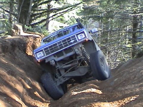 1994 Ford Explorer - Blue SUV navigates a steep dirt incline during an off-road excursion.