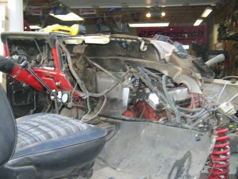 1979 Ford Bronco - The interior of a vehicle shows significant damage, with the engine and wiring exposed.