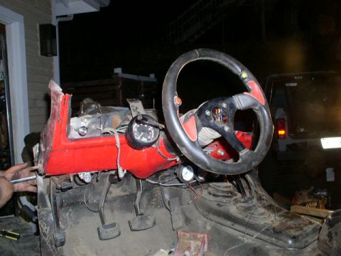 1979 Ford Bronco - The interior of a vehicle is shown with the dashboard disassembled, revealing pedals, gauges, and wiring.
