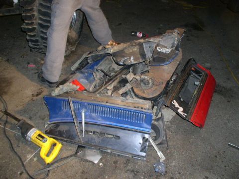 1979 Ford Bronco - Damaged vehicle parts are laid out on the ground next to a yellow reciprocating saw.
