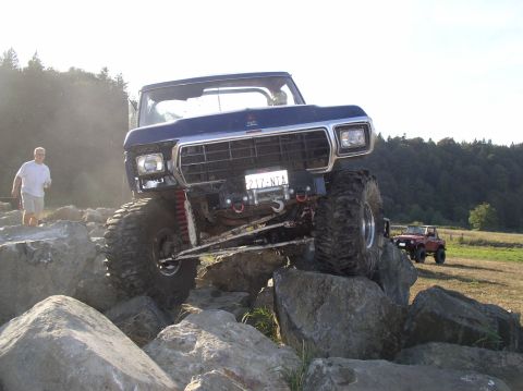 1979 Ford Bronco - Modified Ford truck navigates a rocky obstacle course with a second vehicle visible in the distance.