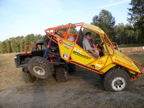 1979 Ford Bronco - A custom-built off-road buggy is parked next to a pickup truck on a dirt lot.