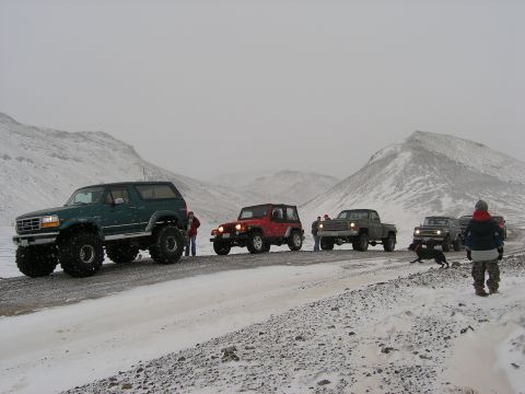 2001 Jeep Wrangler - A group of off-road vehicles navigates a snowy mountain pass during a trip.