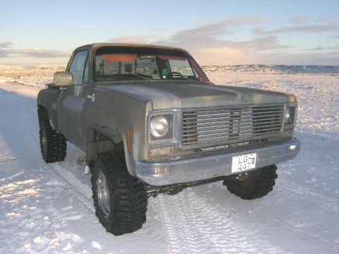 2001 Jeep Wrangler - This pickup truck, likely from the mid-1970s, is equipped with large off-road tires and is parked on a snowy surface.