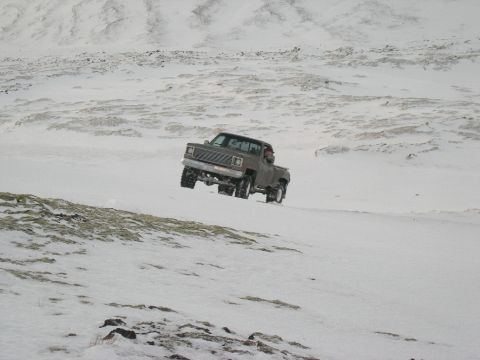 2001 Jeep Wrangler - Pickup truck navigates a snowy incline, demonstrating off-road capability.