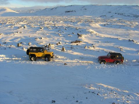 2001 Jeep Wrangler - Two Jeeps navigate a snowy, desolate landscape under a bright sky.