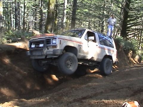 1994 Ford Explorer - This off-road SUV navigates a steep dirt trail in a wooded area.