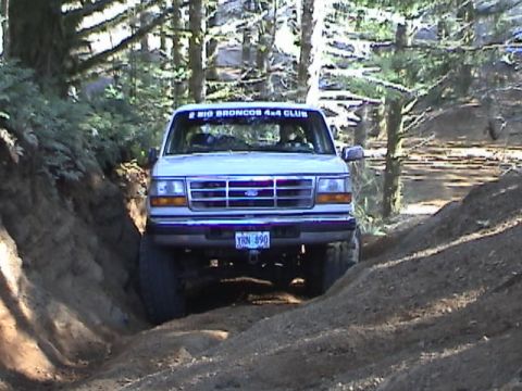 1994 Ford Explorer - Ford Explorer navigates a challenging off-road trail, displaying a club banner on its windshield.