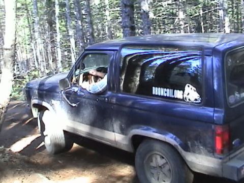 1994 Ford Explorer - A blue SUV navigates a wooded trail, displaying a club sticker on its rear window.