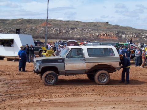 2004 Aston Martin Virage - A two-tone SUV is seen in a muddy area with spectators observing the scene.