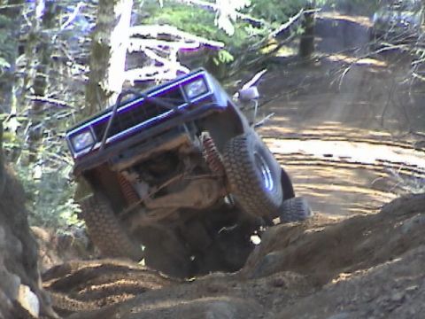 1994 Ford Explorer - An off-road SUV navigates a challenging dirt incline, its suspension and tires.