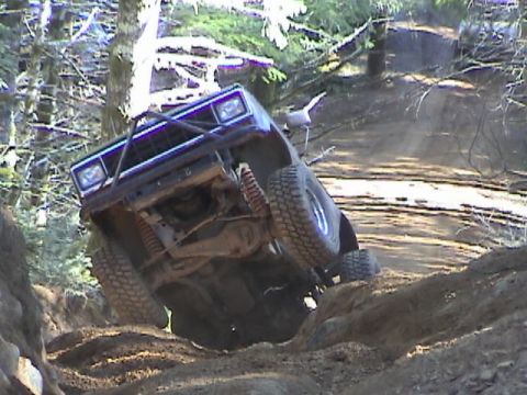 1994 Ford Explorer - This vehicle is navigating a challenging off-road trail with steep inclines and rough terrain.