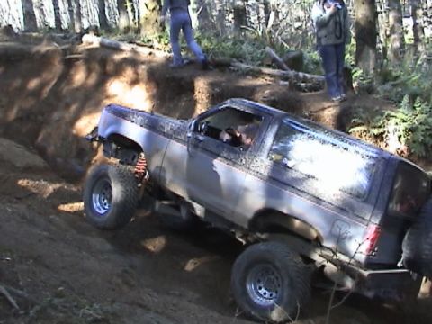 1994 Ford Explorer - Silver SUV with black trim navigates a steep dirt incline with its front wheel lifted.