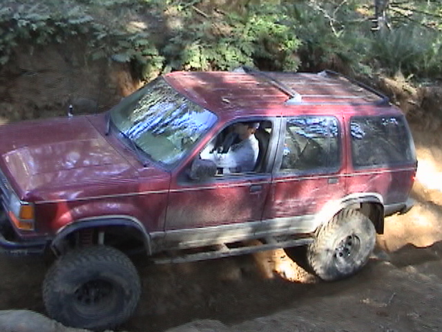 Red 1994 Ford Explorer off-roading on a dirt trail