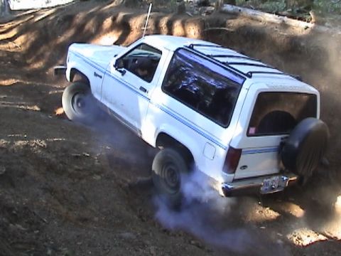 1994 Ford Explorer - A white Ford Bronco II navigates a steep, dusty incline off-road.