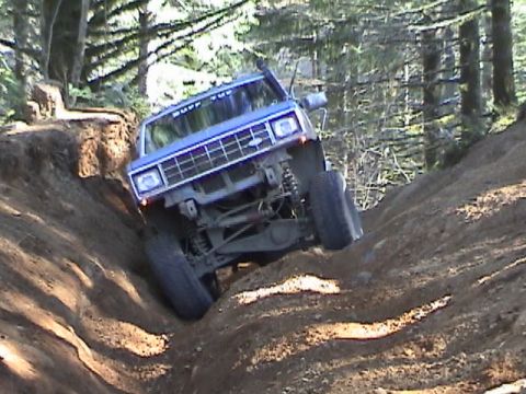 1994 Ford Explorer - A blue SUV navigates a challenging off-road trail, demonstrating its off-road capabilities.