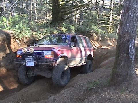 1994 Ford Explorer - This 1994 Ford Explorer is navigating a challenging dirt trail with its tires digging into the terrain.