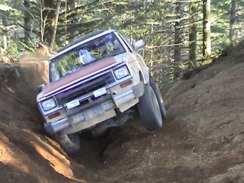 1994 Ford Explorer - Ford Bronco II navigating a challenging off-road course on a sunny day.