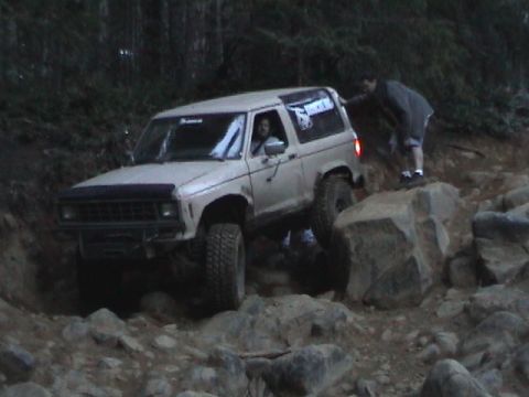 1994 Ford Explorer - A person is guiding a Ford Bronco II over a difficult rocky terrain.
