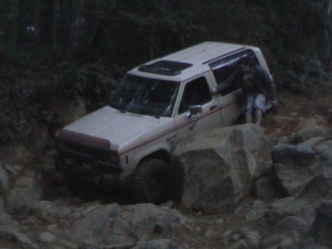 1994 Ford Explorer - White SUV navigating a difficult rocky trail with the driver's door open.