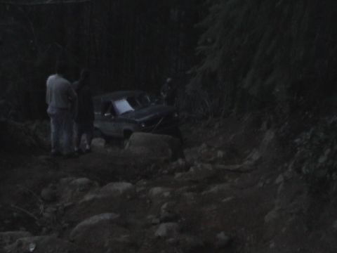 1994 Ford Explorer - An off-road vehicle navigates a difficult, rocky path in a wooded area.
