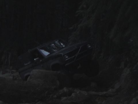 1994 Ford Explorer - A vehicle navigates a challenging, rocky path in low-light conditions.
