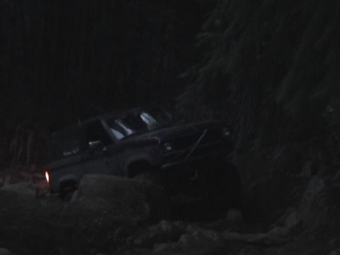 1994 Ford Explorer - An off-road vehicle is seen on a rocky trail at night, with limited visibility.