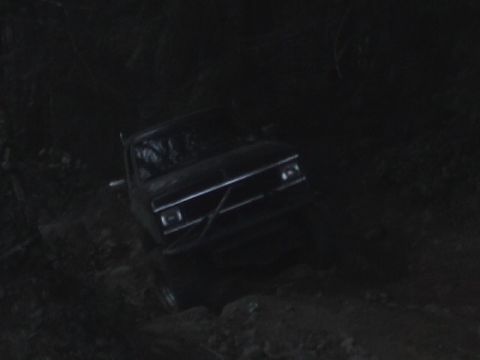 1994 Ford Explorer - A dark Ford Bronco II is seen on a rough dirt path in the dark.