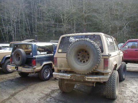 1994 Ford Explorer - Two Ford Bronco II SUVs are parked on a dirt road, likely during an off-road event.