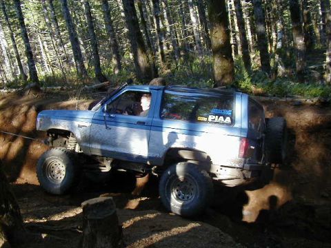 1994 Ford Explorer - This lifted SUV navigates a challenging dirt trail through a wooded area.