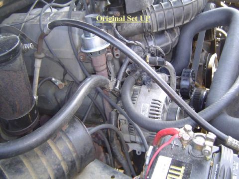 1993 Ford Bronco - Close-up view of an engine bay, showing various components and hoses, with overlaid text indicating the original setup.