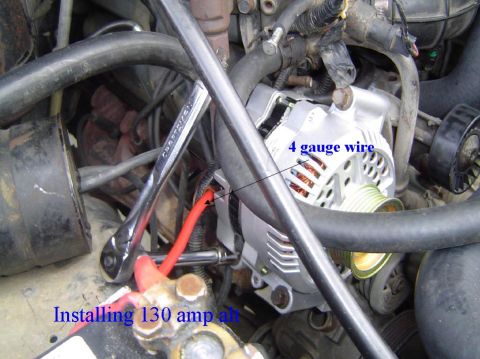 1993 Ford Bronco - Close-up view of an alternator being installed in a vehicle's engine bay.