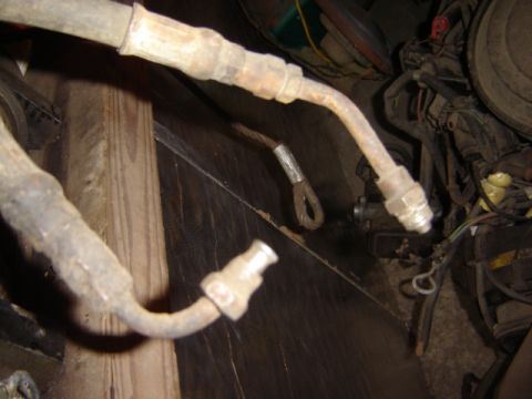 1992 Ford Bronco - Close-up view of aged brake lines and engine parts, with visible wooden structural elements.