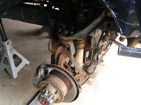 1986 Ford F-150 - Close-up view of the front suspension and wheel assembly of a 1986 Ford F-150.