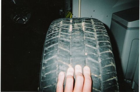 2000 Ford Crown Victoria - A tire is shown in detail, with a hand providing a sense of its size.