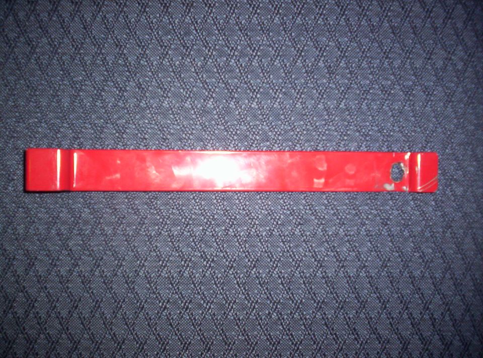 Red plastic trim removal tool with a hole on the right end