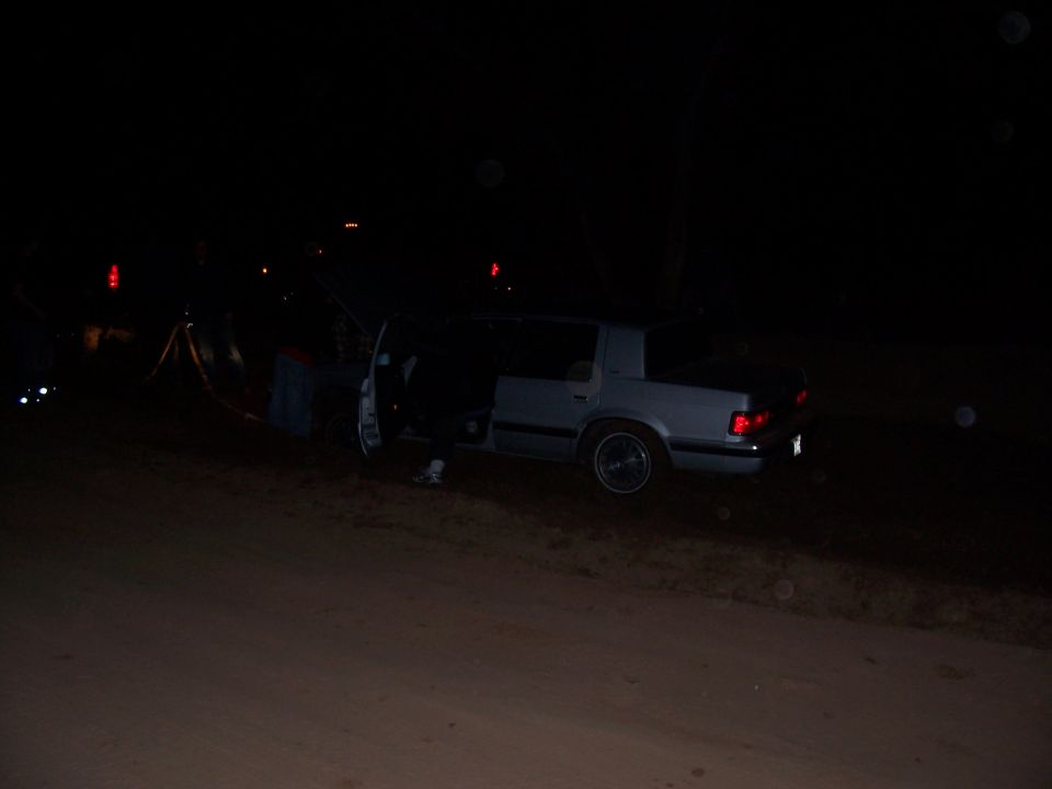 Silver sedan with doors open at night