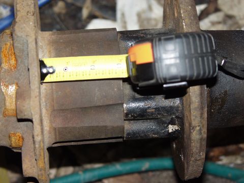 1979 Ford Bronco - A tape measure is used to measure the width of a vehicle's axle housing.