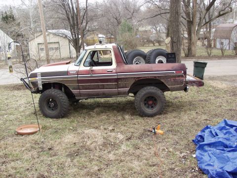 1979 Ford Bronco - This modified Ford Bronco sits in a yard with spare tires loaded in the cargo area.