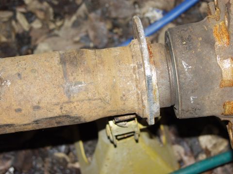 1979 Ford Bronco - A close-up view of a rusty axle component, likely from a vehicle, resting on a yellow jack stand.