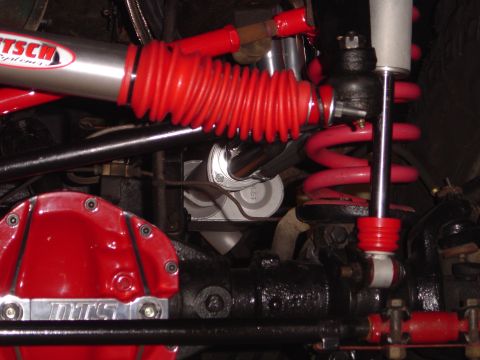 1978 Ford Bronco - Close-up view of modified vehicle suspension parts, including a differential cover and shock absorber.