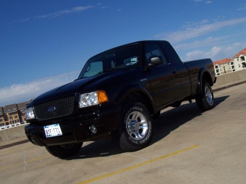 2003 Ford Ranger - Black 2003 Ford Ranger pickup truck parked on a concrete surface under a clear blue sky.
