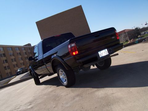 2003 Ford Ranger - Rear 3/4 view of a black 2003 Ford Ranger pickup truck parked in a lot.