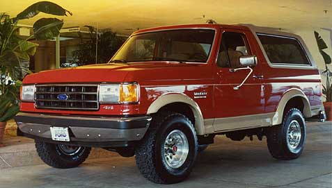1993 Ford Bronco - This 1993 Ford Bronco features a two-tone red and tan paint scheme with prominent fender flares.